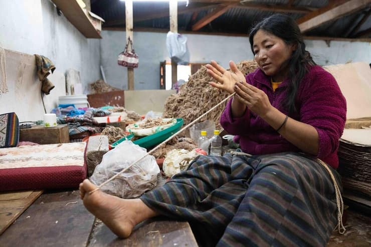 אישה מקומית עמלת על טווית חוטים במפעל לייצור נייר (צילום: טל שחר) אישה מקומית עומלת על טווית חוטים במפעל לייצור נייר