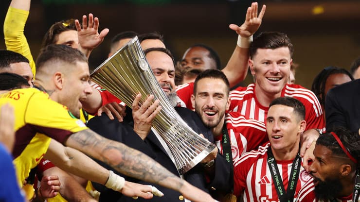 מרינאקיס חוגג עם שחקני אולימפיאקוס את הזכייה בקונפרנס-ליג