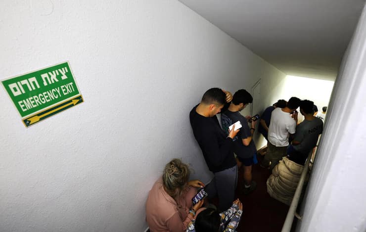 ישראלים תופסים מחסה בזמן אזעקה בתל אביב, בעקבות ירי טילים. "זה לא מגיע לכם" (צילום: Kai Pfaffenbach / רויטרס) תל אביב