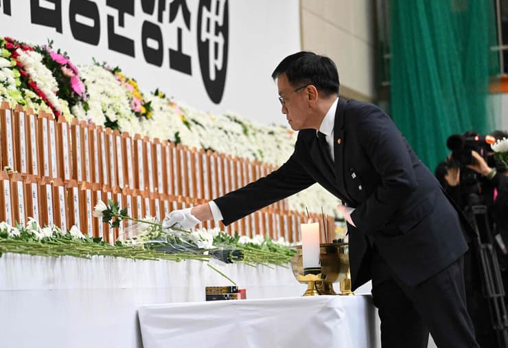נשיא דרום קוריאה בפועל ושר האוצר צ'וי סאן-מוק מניח פרחים לזכר נספי אסון התרסקות מטוס בנמל התעופה ב מואן 