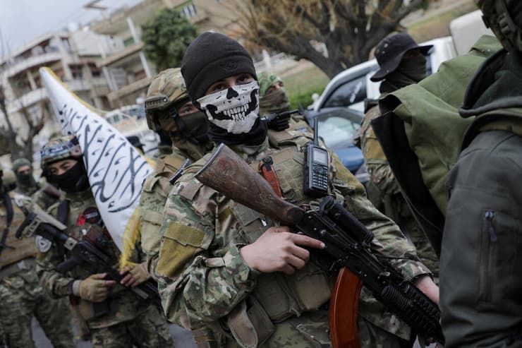 אנשי הייאת תחריר א-שאם במצעד בדמשק. ארגוני המורדים משתלבים בכוחות הביטחון בסוריה (צילום: REUTERS/Khalil Ashawi/File Photo) מורד סורי מצעד צבאי ב דמשק אחרי הפלת אסד סוריה