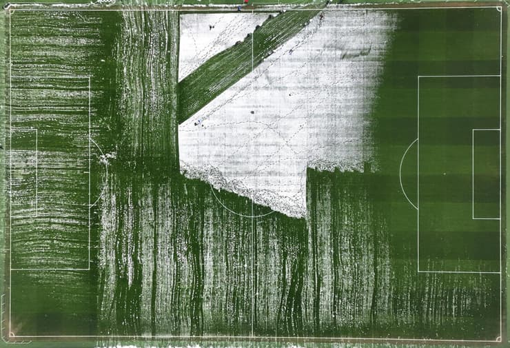 כר הדשא והשלג שנותר עליו אחרי שחלק גדול כבר פונה. אנפילד, היום (צילום: Carl Recine/Getty Images) בריטניה מזג אוויר גל קור ליברפול אנפילד