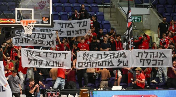 אוהדי הפועל ירושלים עם שלטים נגד המנהלת