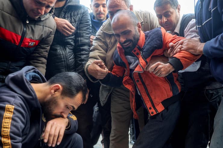 בבית החולים בדיר אל-בלח, עזה (צילום: AFP / EYAD BABA) אבלים בבית החולים בדיר אל-בלח, עזה, בעקבות הפצצה ישראלית, 12 לינואר 2025