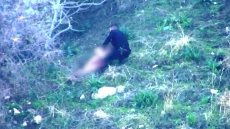 השוטר עוצר את החשוד, שמנסה להיאבק בו בעודו עירום. את בגדיו הסתיר מתחת לערימת עלים (צילום: דוברות המשטרה) תיעוד החשוד שגנב משאית בטבריה ואותר עירום במנהרה