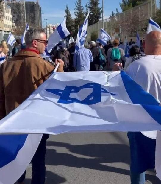 צועדים מחזיקים את דגל ישראל כאלונקה, בצעדה מהר הרצל לכנסת בקריאה לשיוויון בנטל