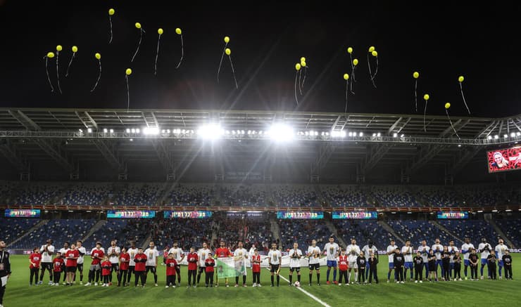 שחקני הפועל חיפה מפריחים בלונים צהובים בקריאה להשבת כל החטופים (צילום: גיל נחושתן) הטקס לכבוד רומי גונן