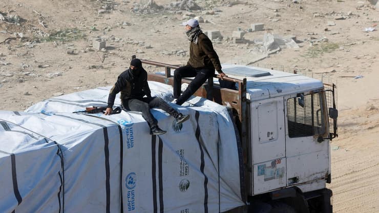 חמושים שהשתלטו על משאית סיוע בעזה (צילום: AP Photo/Jehad Alshrafi) רפיח עזה משאיות סיוע הומניטרי