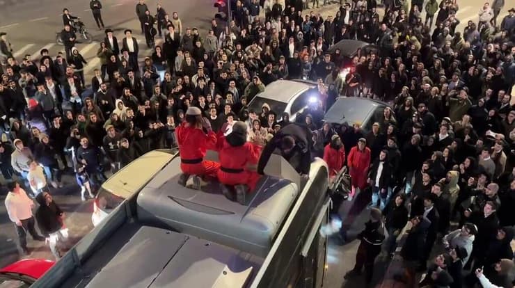 המפגינים המתיישבים עולים על אוטובוס שתקוע בחסימה בעקבות ההפגנה