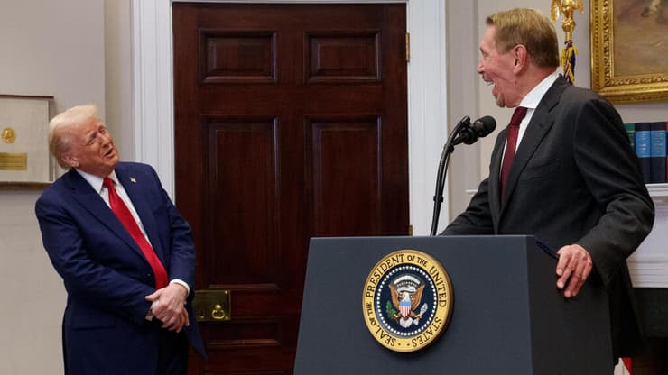 לארי אליסון והנשיא טראמפ צוחקים כאשר אליסון משתמש בהדום לעמוד עליו במהלך מסיבת עיתונאים בבית הלבן