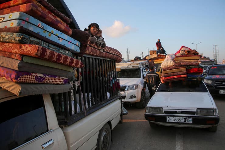 צילום: REUTERS/Hatem Khaled המוני עזתים ממתינים לעבור עם הרכב