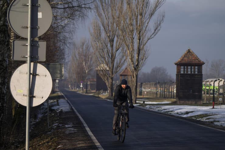 גבר רוכב על אופניים מחוץ לאושוויץ