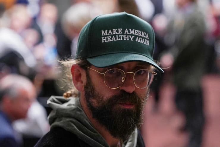 תומך של רוברט פ' קנדי ג'וניור מועמדו של טראמפ ל שר הבריאות של ארה"ב במהלך שימוע ב סנאט עם כובע שעליו נכתבה הסיסמה "להפוך את אמריקה לבריאה שוב"