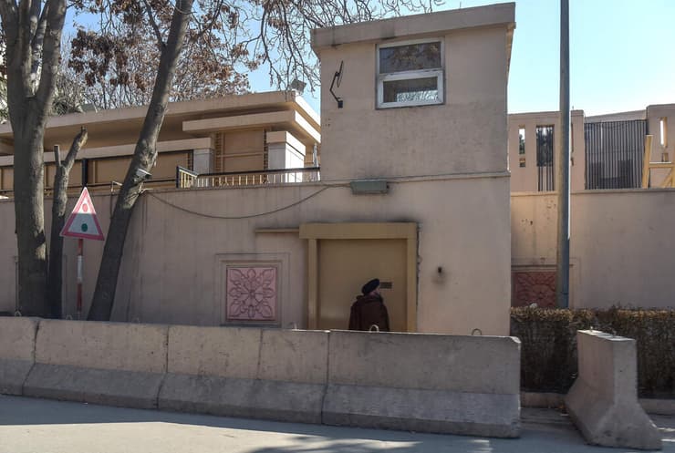 גבר אפגני עומד בשער הכניסה של מלון סרנה בקאבול, ב-1 בפברואר