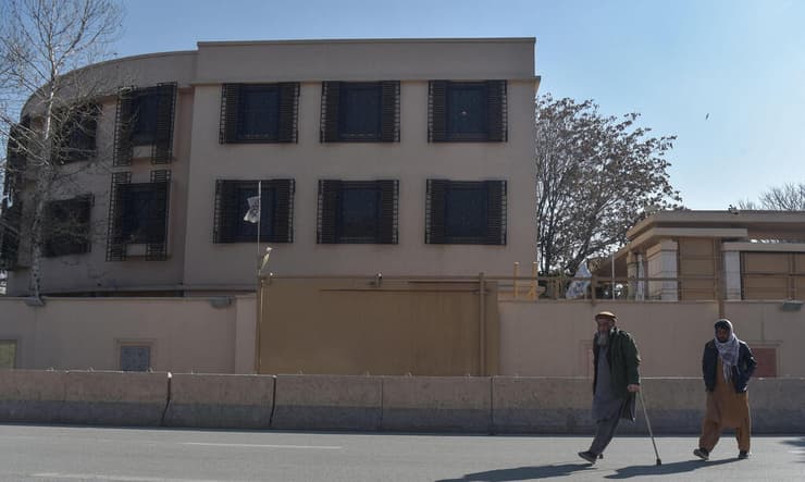 גבר אפגני עם מוגבלות חולף על פני מלון סרנה בקאבול, ב-1 בפברואר 2025