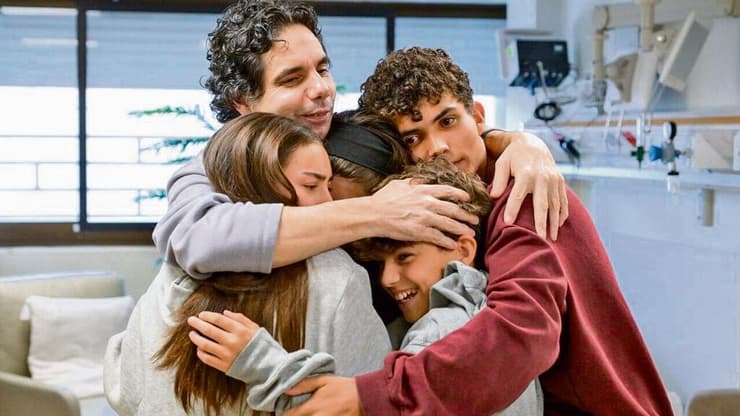 עופר קלדרון מחבק את ילדיו לאחר שחרורו מהשבי