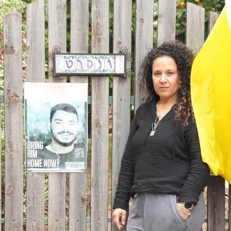 ניבה ונקרט מחוץ לביתה. על השער - תמונתו של עומר (צילום: תומר שונם הלוי) ניבה ונקרט