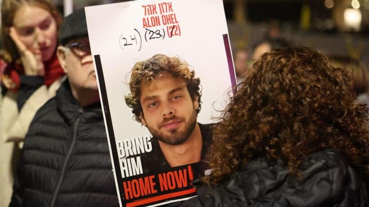 מניפים את תמונתו של אלון אהל בכיכר החטופים (צילום: מוטי קמחי) ציון יום הולדתו של החטוף אלון אהל בכיכר החטופים