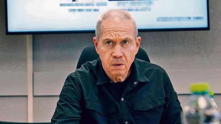 גלנט. תומך בחידוש האש בעזה (צילום: משרד הביטחון) יואב גלנט על רקע תמונות האחים סינוואר