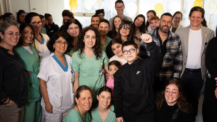 אסמאר שופי זייתון עם משפחתו ועם אנשי צוות בית החולים דנה שטיפלו בו במסע השיקום הארוך (צילום: יובל חן) אסמאר שופי זייתון נפצע קשה באסון רקטה במג'דל שמס שוחרר מאיכילוב