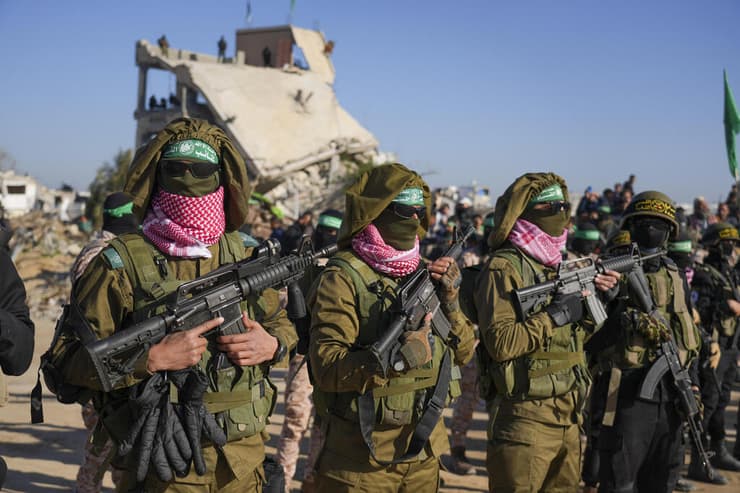 לרוסיה, הקשר הזה נוח. מחבלי חמאס בחאן יונס בעת העברת החטופים (צילום: AP/Abdel Kareem Hana) הבמה בחאן יונס לקראת העברת החטופים