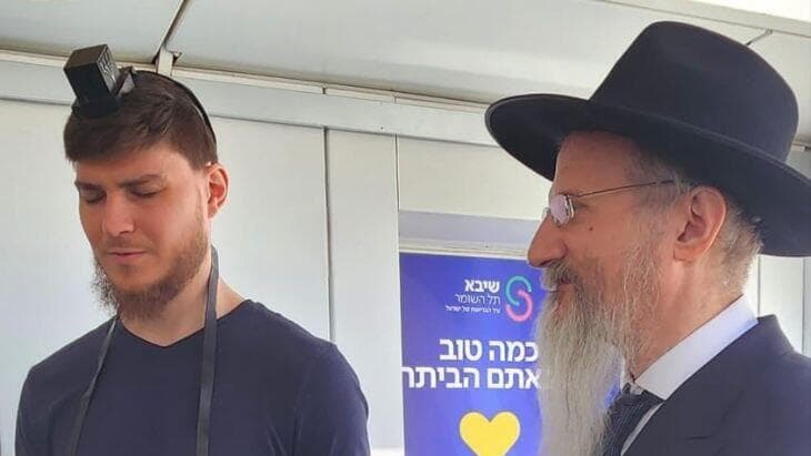 סשה טרופנוב מניח תפילין עם רבה הראשי של רוסיה הרב לאזאר