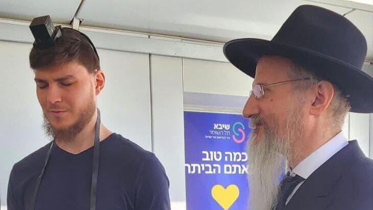 סשה טרופנוב מניח תפילין עם רבה הראשי של רוסיה הרב לאזאר