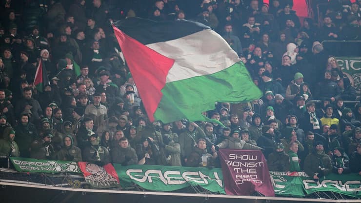 אוהדי סלטיק עם דגל פלסטין והשלט האנטי-ישראלי (Matthias Hangst/Getty Images) אוהדי סלטיק עם דגל פלסטין ושלט אנטי ישראלי