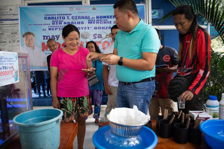 קרליטו סרנל במעמד מתן התגמול. 21 "ציידים" כבר הגיעו (צילום: Ted ALJIBE / AFP) הפיליפינים פיליפינים קרליטו סרנל משלם ל תושבים מבצע לכידת יתושים