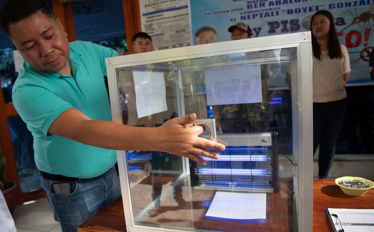 קרליטו סרנל ו"תא ההוצאה להורג" המיועד ליתושים (צילום: Ted ALJIBE / AFP) הפיליפינים פיליפינים קרליטו סרנל תא הוצאה להורג ל יתושים