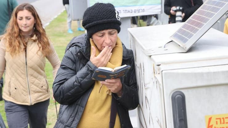 אישה נושאת תפילה במכון לרפואה משפטית (צילום: מוטי קמחי) אזרחית הגיעה לשאת תפילה ולתמוך בסמוך לאבו כביר, המכון לרופאה משפטית במהלך קבלת גופות החטופים