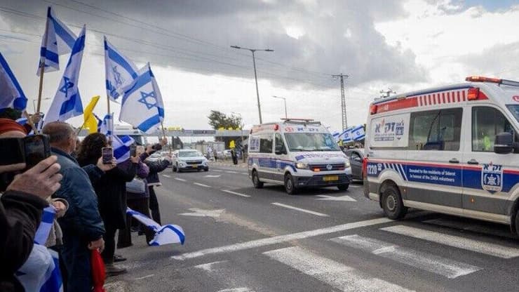 אזרחים תומכים בצומת אשקלון במהלך קבלת החטופים החללים והעברתן לאבו כביר