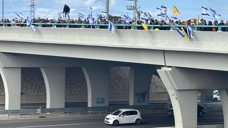 מקבלים את השיירה מעל כביש 4 (צילום: מאיר תורג'מן) אזרחים תומכים בגשר יבנה במהלך קבלת החטופים החללים והעברתן לאבו כביר