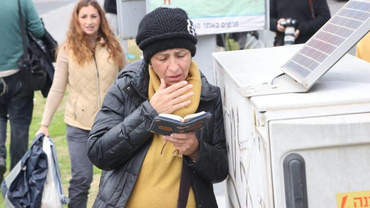 אזרחית הגיעה לשאת תפילה ולתמוך בסמוך לאבו כביר,  המכון לרופאה משפטית במהלך קבלת גופות החטופים
