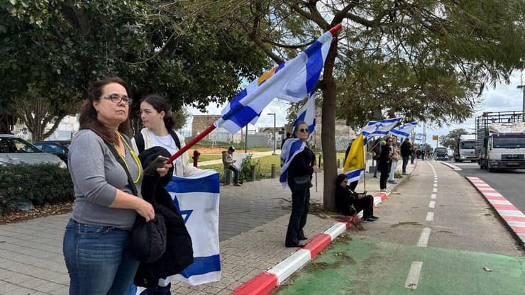 צילום: אור הדר הדרך אבו כביר אזרחים מוכנים עם דגלי ישראל במהלך קבלת גופות החטופים