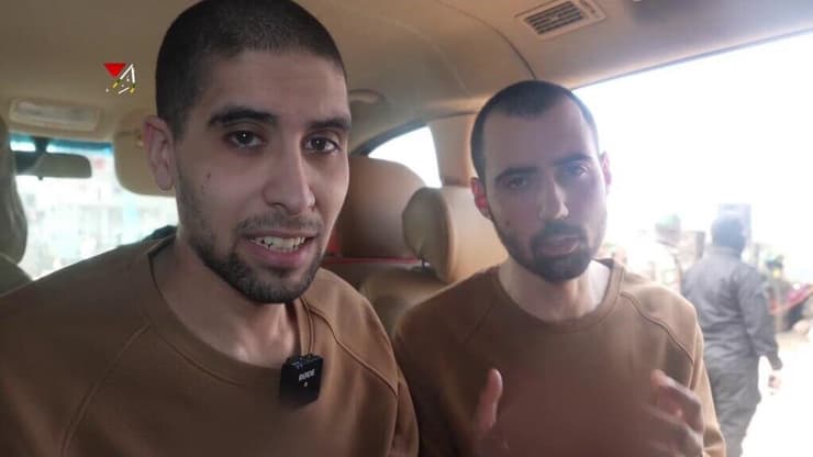 מימין: גיא גלבוע דלאל ואביתר דוד, צופים ב"טקס" של חמאס חמאס הביא את גיא גלבוע דלל ואביתר דוד לצפות בטקס השחרור של חטופים אחרים