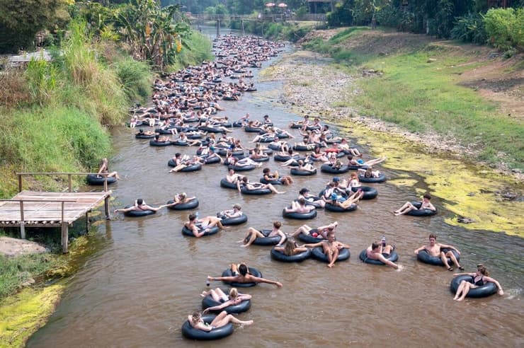 תיירים שטים באבובים בנהר פאי