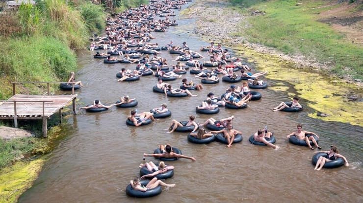 תיירים שטים באבובים בנהר פאי