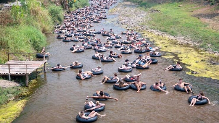 תיירים שטים באבובים בנהר פאי
