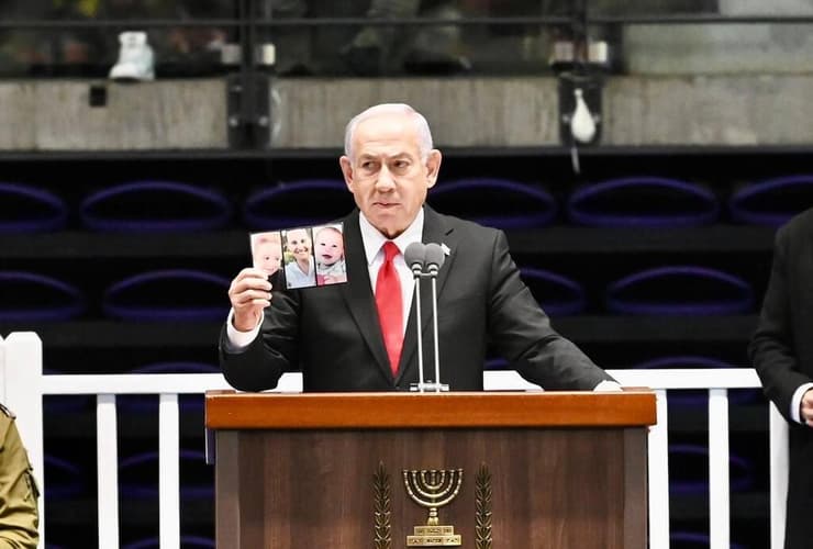 ראש הממשלה בנימין נתניהו מחזיק את תמונת של משפחת ביבס שנרצחו בשבי חמאס, במהלך טקס סיום קורס קצינים קרביים