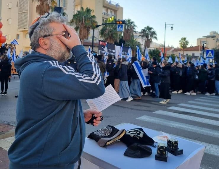 מניחים תפילין בזמן מסע ההלוויה