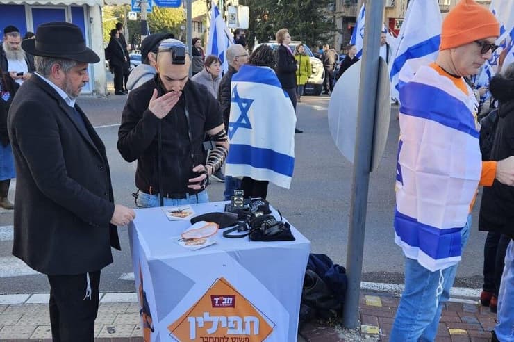 מניחים תפילין בזמן מסע ההלוויה