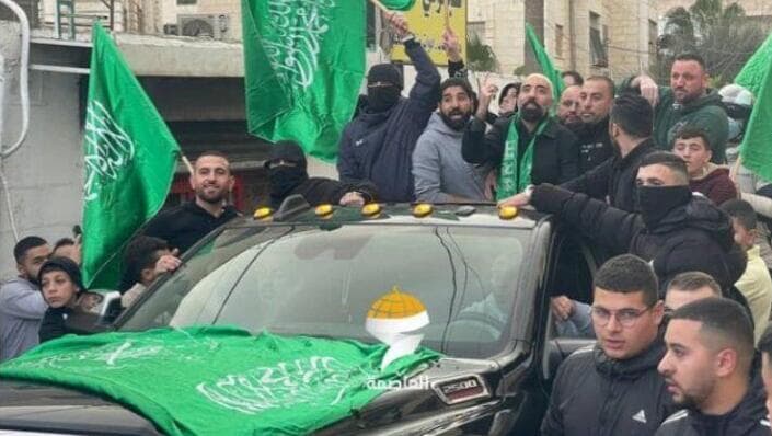 רוכנים מחוץ לרכב עם דגלי חמאס. תיעוד מהחגיגה (צילום: דוברות המשטרה) חגיגות שחרור למחבל בכפר עקב - חקירת אחד החשודים בחגיגת שחרור המחבל