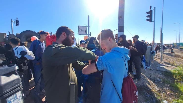 מניחים תפילין בזמן מסע ההלוויה