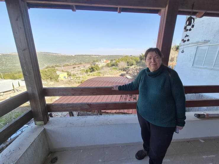 אורה חתן במרפסת שמשקיפה על לבנון