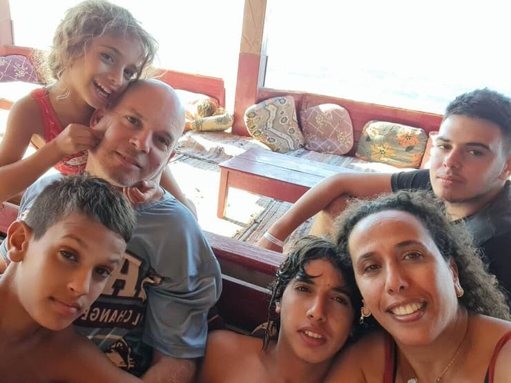תושב נחל עוז רן פוסלושני ז"ל, שנורה בשוגג על ידי צה"ל בביתו ב-7 באוקטובר. בצילום עם אשתו שרונה ו-4 ילדיהם