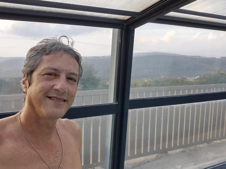 אסף קמר בבריכה המחוממת בשתולה על רקע לבנון