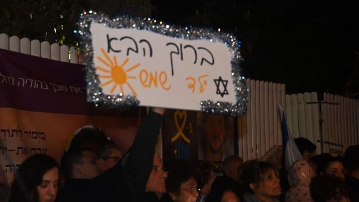 שלטים הונפו לכבוד חזרתו של עומר הביתה (צילום: יאיר שגיא) אזרחים ליד ביתו של עומר שם טוב חוגגים את שחרורו מביה"ח בילינסון והחזרה לביתו