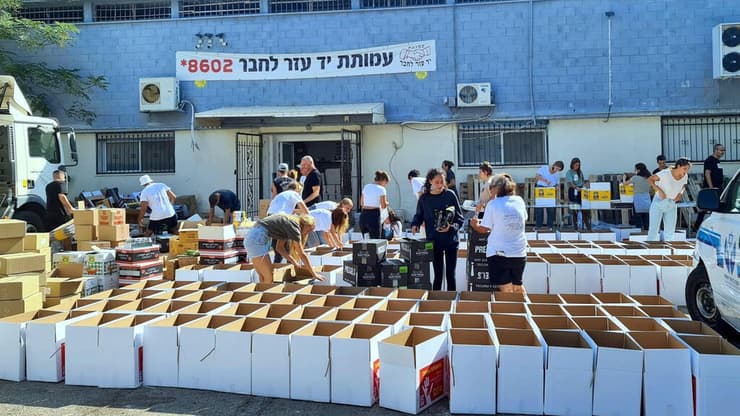 אריזת חבילות מזון עבור משפחות מעוטות יכולת במרכז הלוגיסטי של עמותת יד עזר לחבר