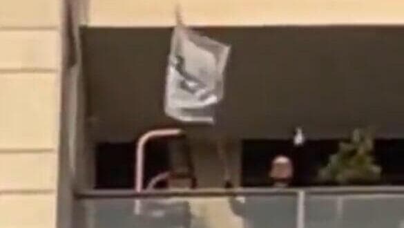 בזמן הקראת שמות חטופים מתחת לביתו של אמיר אוחנה, אדם יוצא עם דגל ליכוד ומניף אצבע משולשת למפגינים